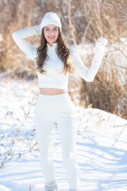Doğada beyaz kışlık giysiler içinde güzel bir genç kadının portresi.