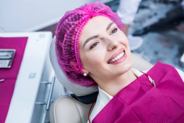 Dişçi, dişçi kliniğinde genç bir kadının dişlerini muayene ediyor. Dişçi konsepti. Diş hekimi ve hasta muayenehanesinde..