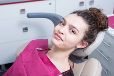 Stomatoloji ve diş bakımı. Diş hekimliği ve oral sağlık. Kadının dişçi kliniğinde diş muayenesi var. Yaklaş genç beyaz kız yüzü..