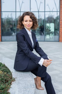 Modern iş binasının önünde başarılı bir iş kadınının portresi. Genç yönetici dışarıda poz veriyor. Kadın iş adamı..