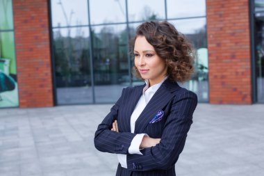 Modern iş binasının önünde başarılı bir iş kadınının portresi. Genç yönetici dışarıda poz veriyor. Kadın iş adamı.