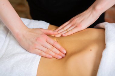 Kaplıca salonunda sırt masajı yaptıran genç bir kadın. Güzellik tedavisi konsepti. Kaplıca salonunda mükemmel cilde sahip güzel bir genç kadının portresi..