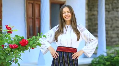 Kırsalda Rumen geleneksel bluzu giyen genç bir kızın videosu. Romanya geleneğinin özgün ulusal kostümü.