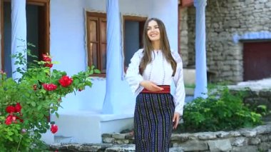 Kırsalda Rumen geleneksel bluzu giyen genç bir kızın videosu. Romanya geleneğinin özgün ulusal kostümü.