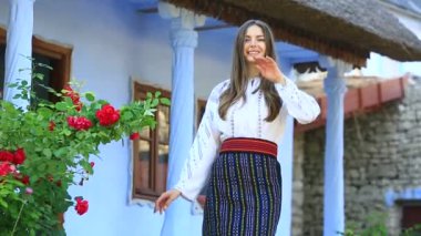 Kırsalda Rumen geleneksel bluzu giyen genç bir kızın videosu. Romanya geleneğinin özgün ulusal kostümü.