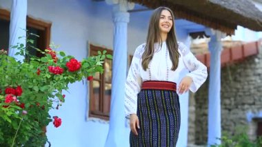 Kırsalda Rumen geleneksel bluzu giyen genç bir kızın videosu. Romanya geleneğinin özgün ulusal kostümü.