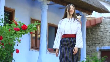 Kırsalda Rumen geleneksel bluzu giyen genç bir kızın videosu. Romanya geleneğinin özgün ulusal kostümü.