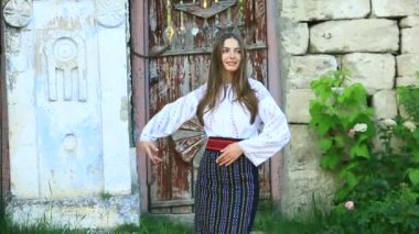 Kırsalda Rumen geleneksel bluzu giyen genç bir kızın videosu. Romanya geleneğinin özgün ulusal kostümü.