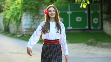 Kırsalda Rumen geleneksel bluzu giyen genç bir kızın videosu. Romanya geleneğinin özgün ulusal kostümü.