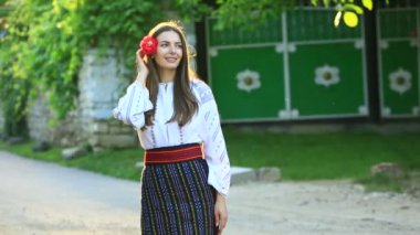 Kırsalda Rumen geleneksel bluzu giyen genç bir kızın videosu. Romanya geleneğinin özgün ulusal kostümü.