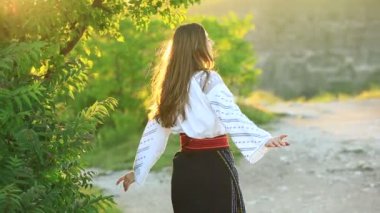 Kırsalda Rumen geleneksel bluzu giyen genç bir kızın videosu. Romanya geleneğinin özgün ulusal kostümü.