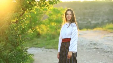 Kırsalda Rumen geleneksel bluzu giyen genç bir kızın videosu. Romanya geleneğinin özgün ulusal kostümü.