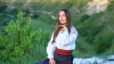 Kırsalda Rumen geleneksel bluzu giyen genç bir kızın videosu. Romanya geleneğinin özgün ulusal kostümü.