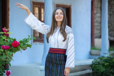 Kırsalda Rumen geleneksel bluzu giyen genç bir kızın videosu. Romanya geleneğinin özgün ulusal kostümü.