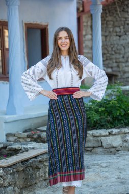Kırsalda Rumen geleneksel bluzu giyen genç bir kızın videosu. Romanya geleneğinin özgün ulusal kostümü.