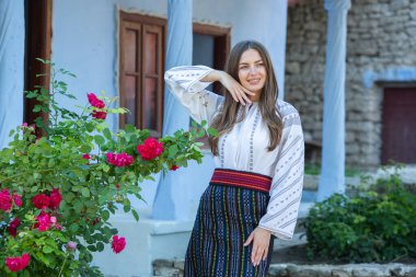 Kırsalda Rumen geleneksel bluzu giyen genç bir kızın videosu. Romanya geleneğinin özgün ulusal kostümü.