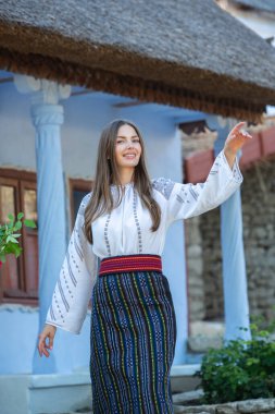 Kırsalda Rumen geleneksel bluzu giyen genç bir kızın videosu. Romanya geleneğinin özgün ulusal kostümü.