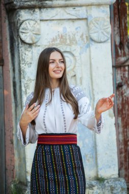 Kırsalda Rumen geleneksel bluzu giyen genç bir kızın videosu. Romanya geleneğinin özgün ulusal kostümü.