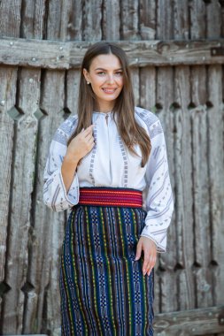 Kırsalda Rumen geleneksel bluzu giyen genç bir kızın videosu. Romanya geleneğinin özgün ulusal kostümü.