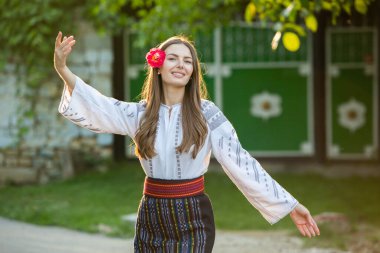 Kırsalda Rumen geleneksel bluzu giyen genç bir kızın videosu. Romanya geleneğinin özgün ulusal kostümü.