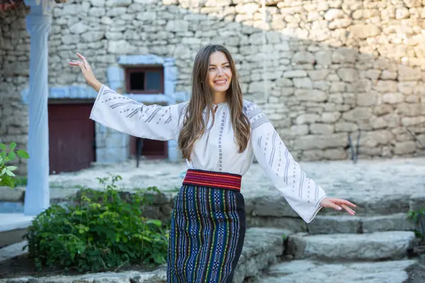 Kırsalda Rumen geleneksel bluzu giyen genç bir kızın videosu. Romanya geleneğinin özgün ulusal kostümü.