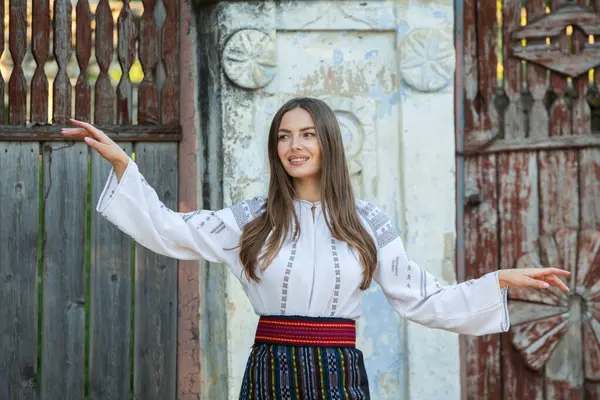 Kırsalda Rumen geleneksel bluzu giyen genç bir kızın videosu. Romanya geleneğinin özgün ulusal kostümü.