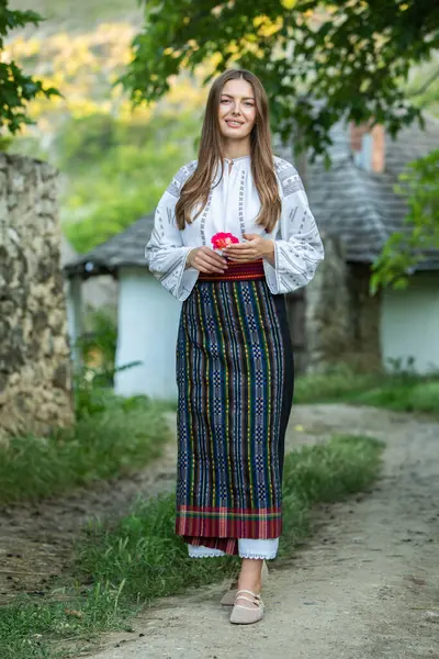 Kırsalda Rumen geleneksel bluzu giyen genç bir kızın videosu. Romanya geleneğinin özgün ulusal kostümü.