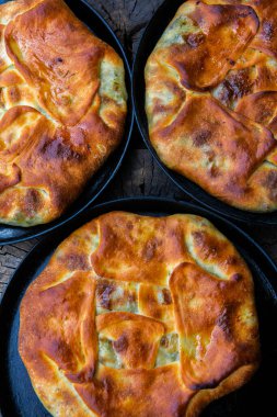 Romen geleneksel peynirli turtası dışarıdaki ateşte tavada pişiyor. Romanya ve Moldova Cumhuriyeti 'nden gıda.