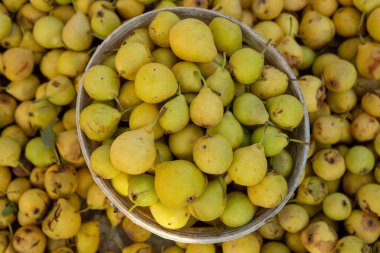 Çiftçi pazarının tezgahında sarı armutlar.