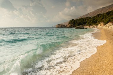 Arnavutluk 'taki İyon Denizi' nin çok güzel bir kıyı şeridi. Arnavutluk 'un dağlarında kumlu bir sahil. Denizde tatil..