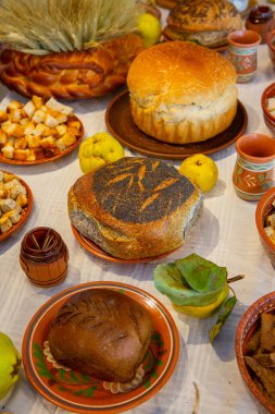 Fırındaki masanın üstünde pişmiş ekmek ve çörekler var. Romanya 'da geleneksel Romen ekmeği masada.
