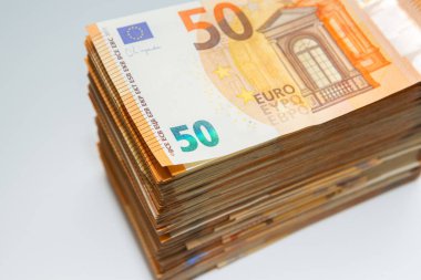 Birçok avro: beyaz arka planda yatan 50 avroluk banknotlar yığını. Enflasyon ve ekonomi Avrupa bölgesi kavramı.