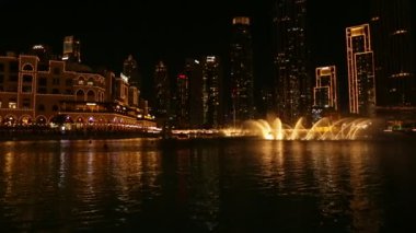 Gece Dubai 'deki dans eden fıskiyelerin videosu. BAE 'deki ünlü ışık ve su fuarı.
