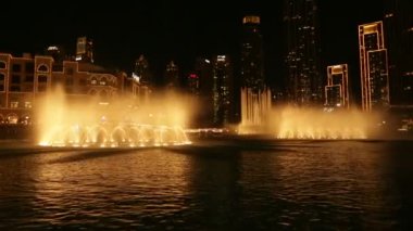 Gece Dubai 'deki dans eden fıskiyelerin videosu. BAE 'deki ünlü ışık ve su fuarı.