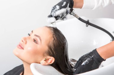 Lüks bir salonda makyajdan zevk alan büyüleyici kadın. Moda Kadını Kuaför Salonunda Kuaför Muamelesi.