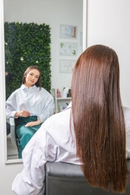 Lüks bir salonda makyajdan zevk alan büyüleyici kadın. Moda Kadını Kuaför Salonunda Kuaför Muamelesi.