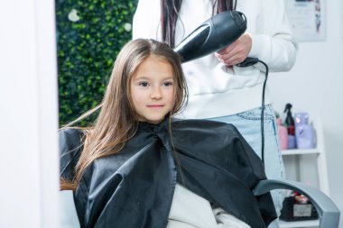 Modern Salon 'da Yeni Saç Tarzı Alınan Mutlu Çocuk. Kuaförde Oturan Küçük Kız Saç Kesimi sırasında