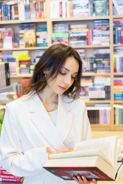 Sessiz Bir Kütüphanede Kitapları Keşfeden Öğrenci. Modern bir kitapçıda kitap arayan bir kız. Okuma konseptini seviyorum. Bilgi..