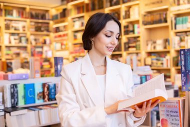 Sessiz Bir Kütüphanede Kitapları Keşfeden Öğrenci. Modern bir kitapçıda kitap arayan bir kız. Okuma konseptini seviyorum. Bilgi..