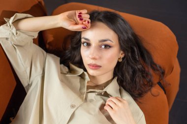 Kanepede poz veren tatlı ve şehvetli genç bir bayan.