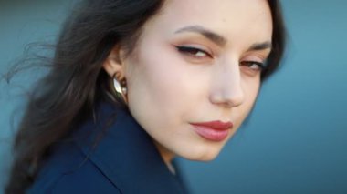 Uzun siyah saçlı ve mavi ceketli güzel bir Asyalı kadının portresi..