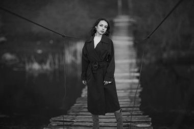 Doğada mavi trençkotlu güzel esmer Avrupalı kız. Güzel yüzlü genç bayan..