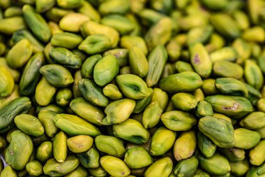 Bir yığın taze, yeşil kabuklu şam fıstığının yakın plan çekimi..