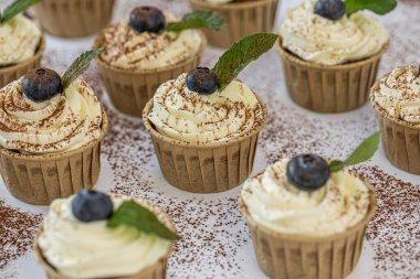 Krem peynirli ve nane yapraklı lezzetli yabanmersinli vanilyalı kekler..