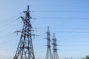 Sahada yüksek voltajlı elektrik hattı var. Akşamları elektrik direkleri. Elektrik kulesi. Güç iletim hatları. Enerji güvenliği ve temiz enerji.  