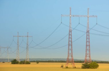 Mavi gökyüzüne karşı yüksek voltajlı elektrik hatları ve kolonlar. Elektrik kulesi. Güç iletim hatları. Enerji güvenliği ve temiz enerji.  