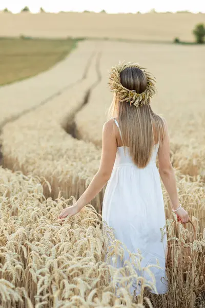 Beyaz elbiseli güzel bir kadının portresi ve tarlada buğday kulaklı bir çelenk.