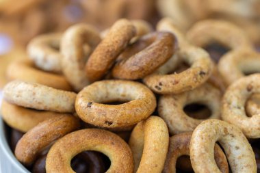 Koyu arkaplanda yeni pişmiş mini simit. Üst Manzara. Yüzük şeklinde krakerler, yakın plan. Küçük ekmek çemberi bisküvisi. Farklı simit türleri olan kaseler..