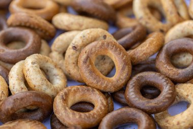 Koyu arkaplanda yeni pişmiş mini simit. Üst Manzara. Yüzük şeklinde krakerler, yakın plan. Küçük ekmek çemberi bisküvisi. Farklı simit türleri olan kaseler..