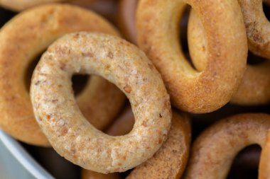 Koyu arkaplanda yeni pişmiş mini simit. Üst Manzara. Yüzük şeklinde krakerler, yakın plan. Küçük ekmek çemberi bisküvisi. Farklı simit türleri olan kaseler..
